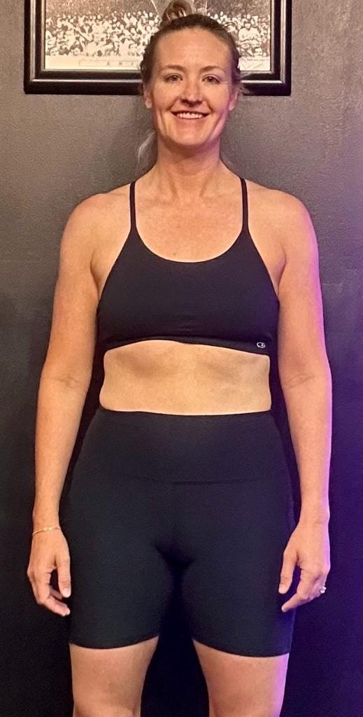 Jenni after 9 months of small group personal training at MVMT Fitness Club Scottsdale — confident, strong, and smiling in black athletic wear