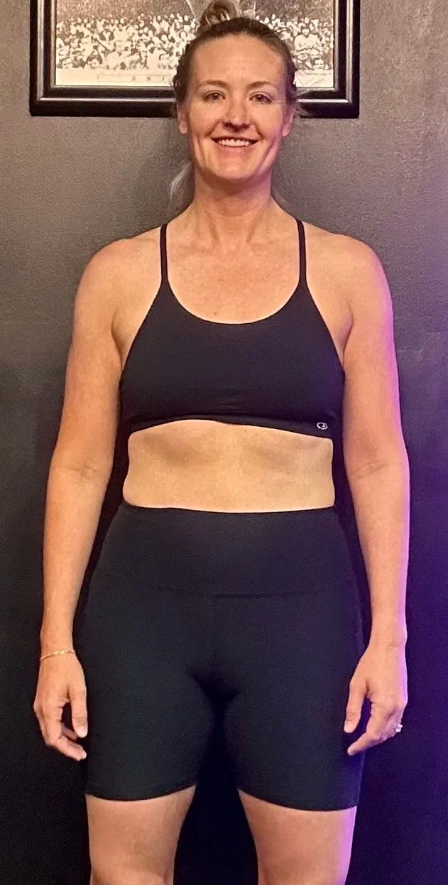 Jenni after 9 months of small group personal training at MVMT Fitness Club Scottsdale β confident, strong, and smiling in black athletic wear